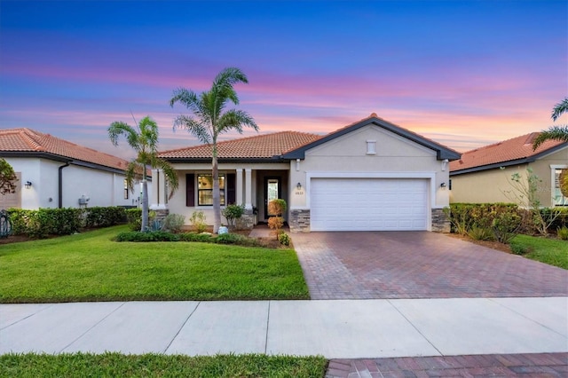 view of front of house featuring a garage and a lawn