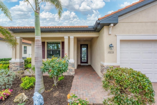 property entrance featuring covered porch and a garage