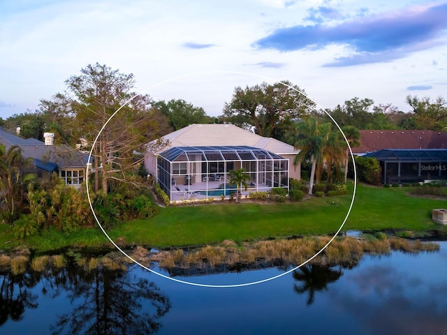 back of property with a water view, a lawn, and a lanai