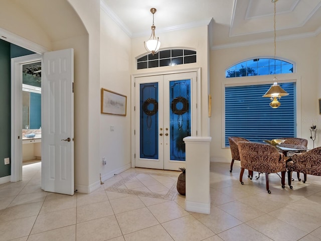 tiled entryway with a towering ceiling, french doors, and crown molding