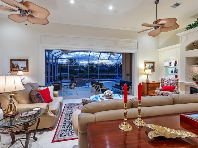 living area featuring ceiling fan, built in shelves, a sunroom, visible vents, and ornamental molding