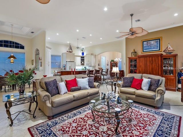 living area featuring visible vents, arched walkways, ceiling fan, crown molding, and recessed lighting