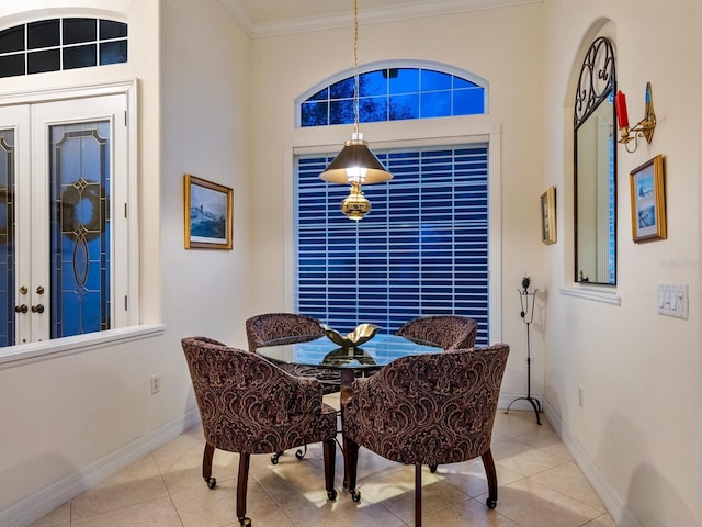 dining room with ornamental molding, light tile patterned flooring, and baseboards