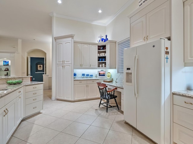 kitchen featuring white cabinets, light tile patterned floors, tasteful backsplash, white fridge with ice dispenser, and crown molding