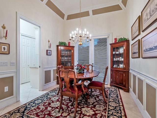 dining area with light tile patterned flooring, an inviting chandelier, and crown molding