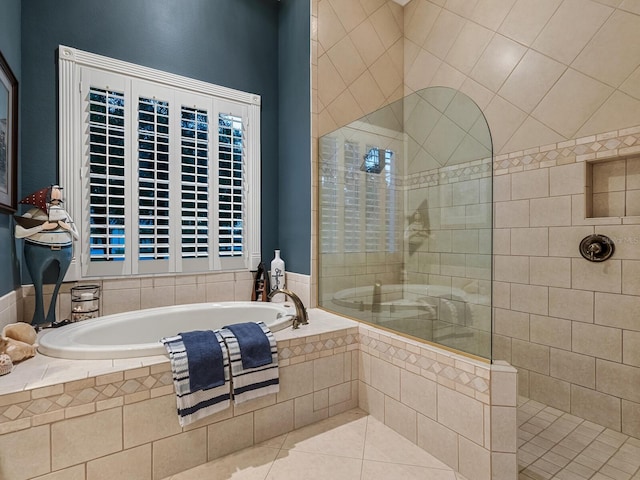 bathroom featuring a walk in shower, tile patterned flooring, and a garden tub