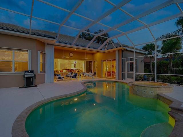 view of pool featuring glass enclosure, a patio, and a pool with connected hot tub