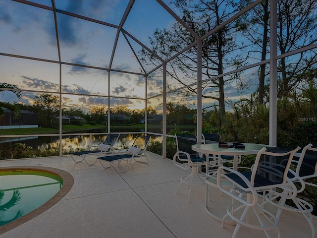 patio terrace at dusk with a water view and a lanai