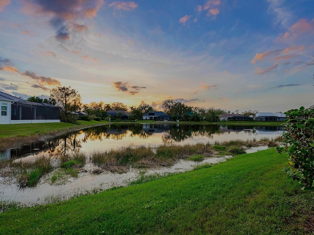 yard at dusk featuring a water view