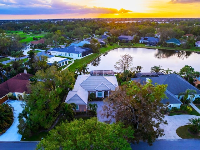 aerial view at dusk featuring a water view