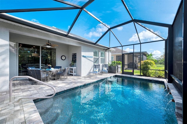 view of swimming pool with a lanai, pool water feature, ceiling fan, and a patio area