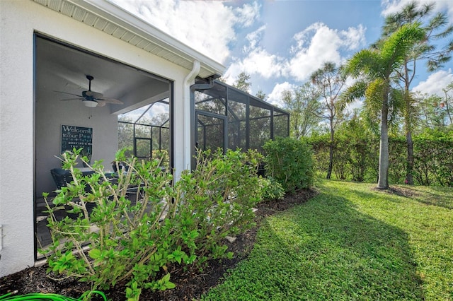 view of yard with ceiling fan and a lanai