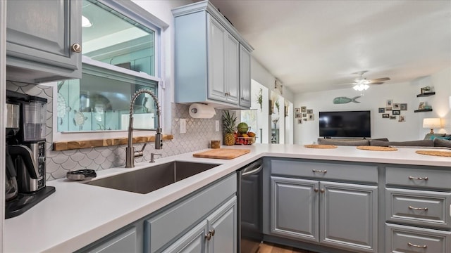 kitchen featuring decorative backsplash, stainless steel dishwasher, ceiling fan, sink, and gray cabinets