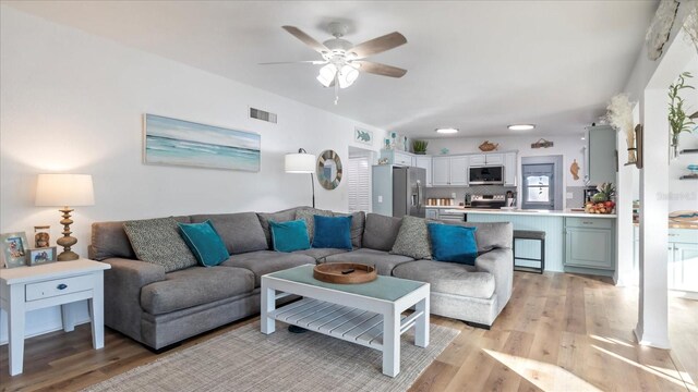 living room featuring ceiling fan and light hardwood / wood-style flooring