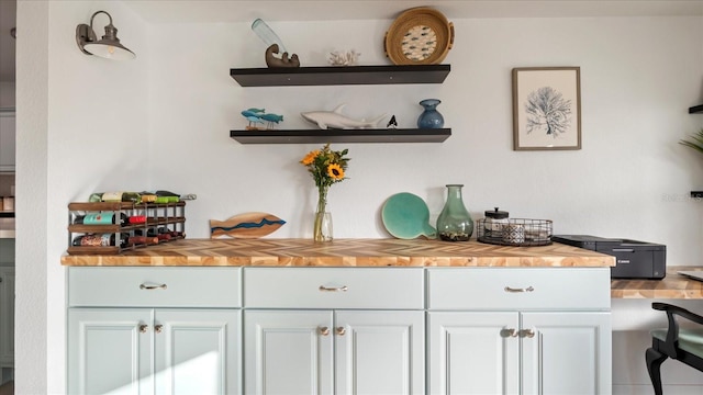 bar with white cabinets, butcher block countertops, and tile patterned floors