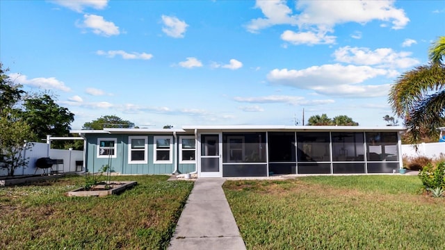 view of front facade featuring a sunroom and a front lawn