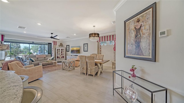 living room featuring light hardwood / wood-style flooring, ceiling fan with notable chandelier, and ornamental molding