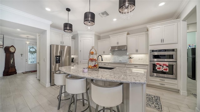 kitchen featuring white cabinetry, a center island with sink, black appliances, and sink