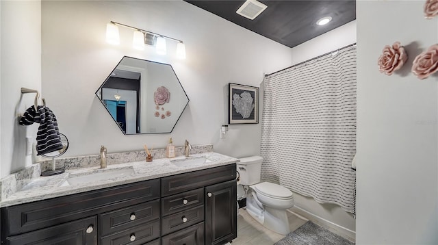 full bathroom with shower / tub combo with curtain, vanity, and toilet