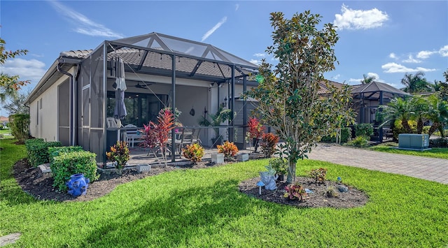 exterior space with glass enclosure and a yard