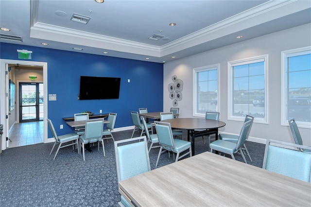 carpeted dining area with french doors, a tray ceiling, plenty of natural light, and crown molding