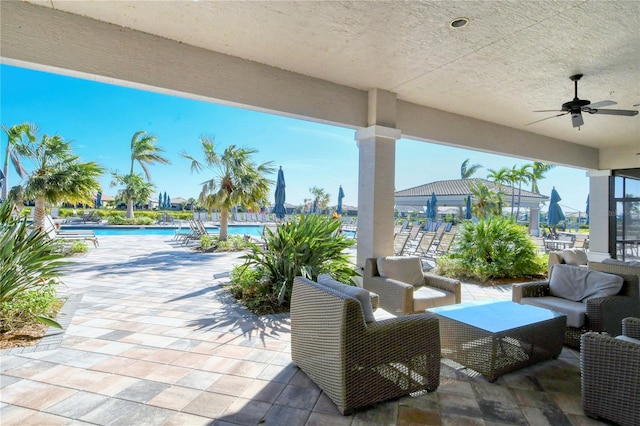 view of patio with an outdoor living space, a community pool, and ceiling fan