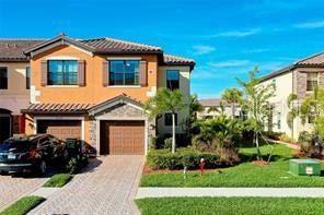 mediterranean / spanish home featuring a garage and a front lawn