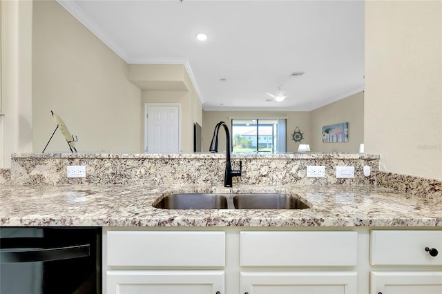 kitchen featuring black dishwasher, light stone countertops, sink, and ornamental molding