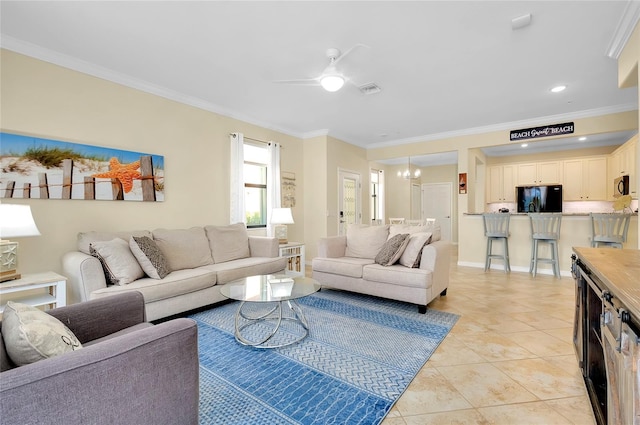 living room with ceiling fan with notable chandelier, light tile patterned floors, and crown molding