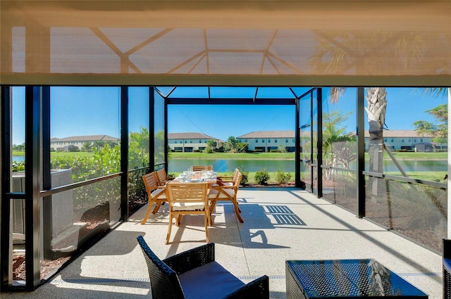 sunroom featuring a water view