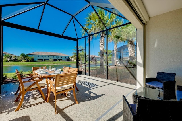 sunroom / solarium featuring a water view and a pool