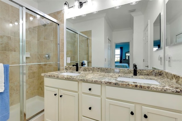 bathroom with vanity, a shower with door, and crown molding