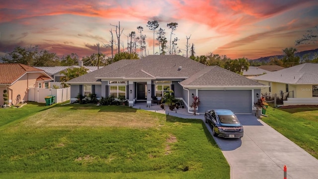 ranch-style house with a garage and a lawn