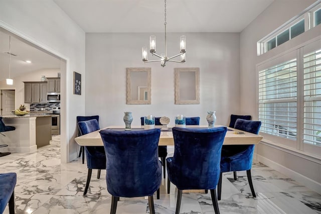 dining area featuring an inviting chandelier and lofted ceiling