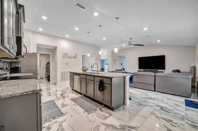 kitchen featuring stainless steel appliances, a kitchen island with sink, light stone countertops, and pendant lighting