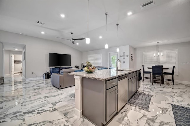 kitchen featuring ceiling fan with notable chandelier, a center island with sink, vaulted ceiling, sink, and pendant lighting