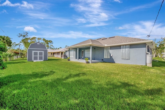 back of house featuring a patio, a lawn, and a storage shed