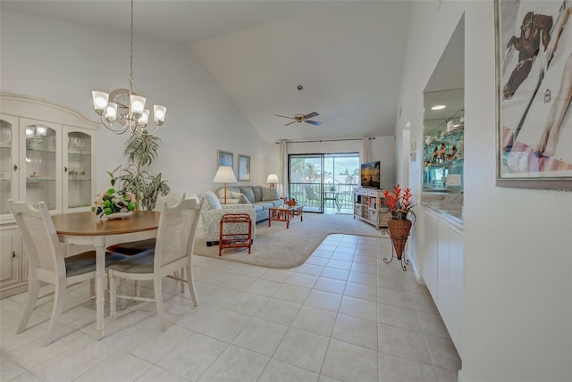 tiled dining space with ceiling fan with notable chandelier and high vaulted ceiling