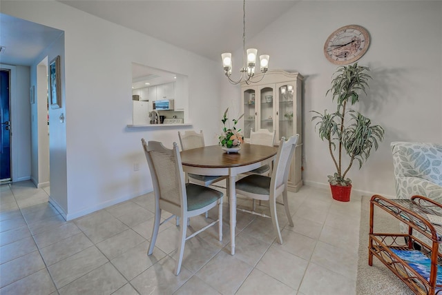 dining space featuring a chandelier, light tile patterned floors, and vaulted ceiling