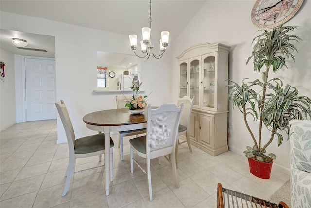 tiled dining space featuring an inviting chandelier and lofted ceiling