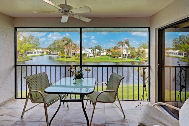 sunroom / solarium with a water view and ceiling fan