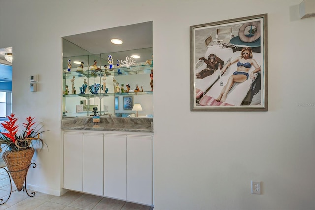 bar featuring white cabinetry and light tile patterned floors