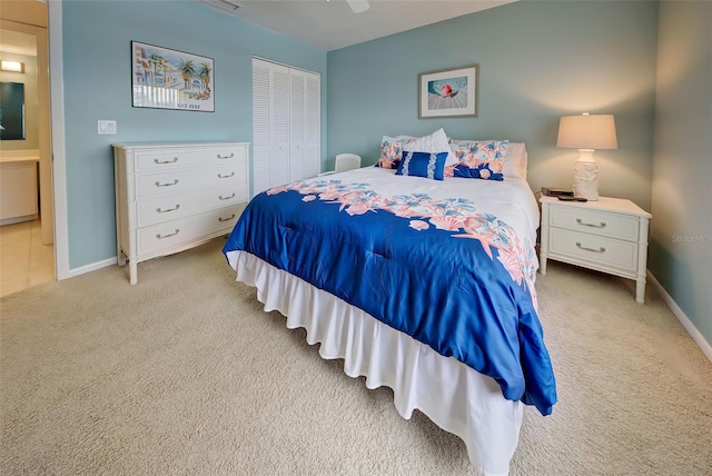 bedroom featuring ceiling fan, a closet, and light colored carpet