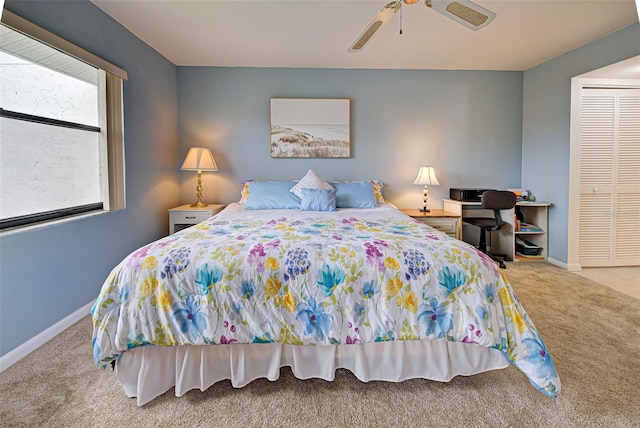 carpeted bedroom with ceiling fan and a closet