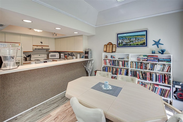 dining space with light wood-type flooring and crown molding