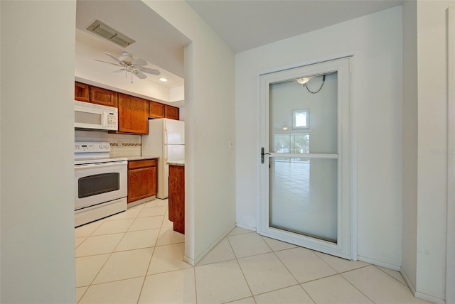 kitchen featuring ceiling fan, light tile patterned flooring, backsplash, and white appliances