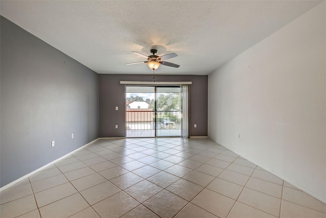 empty room with light tile patterned flooring, ceiling fan, and a textured ceiling