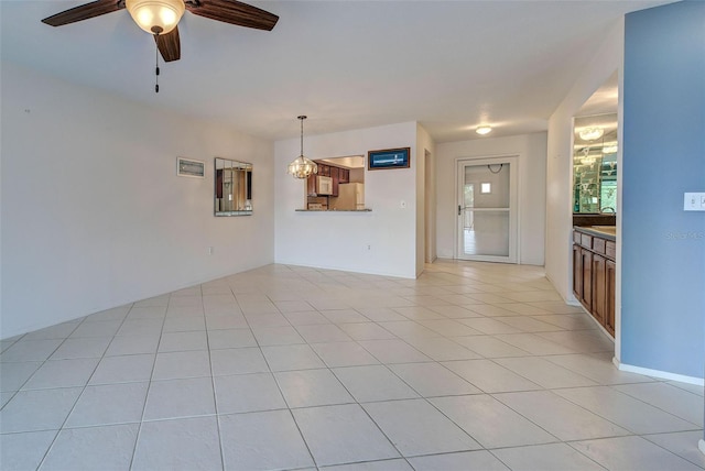 unfurnished living room with light tile patterned flooring, sink, and ceiling fan