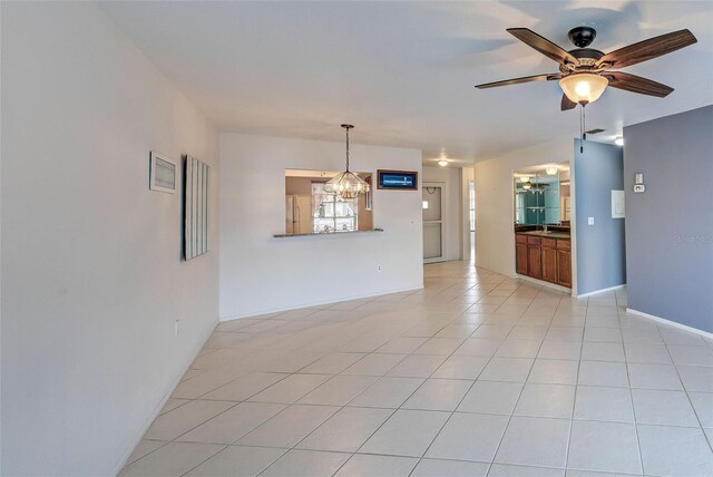 empty room with light tile patterned floors and ceiling fan with notable chandelier