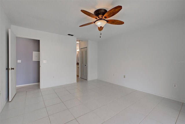 tiled spare room featuring ceiling fan